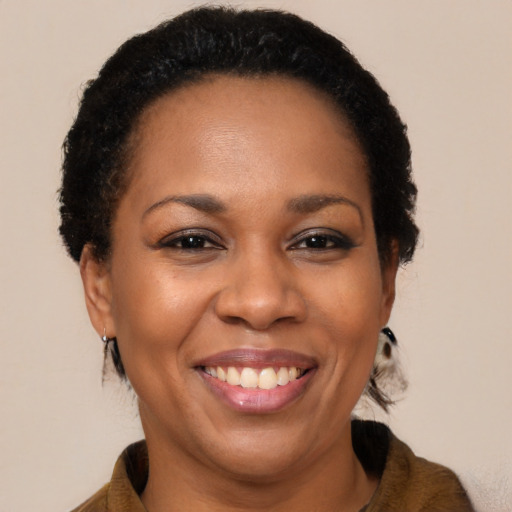 Joyful black adult female with long  brown hair and brown eyes
