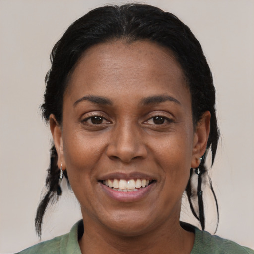 Joyful black adult female with medium  brown hair and brown eyes