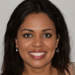 Joyful black young-adult female with long  brown hair and brown eyes