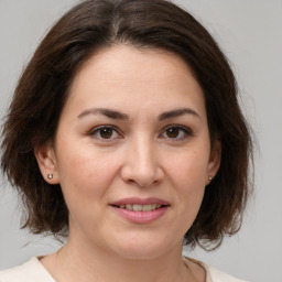 Joyful white adult female with medium  brown hair and brown eyes