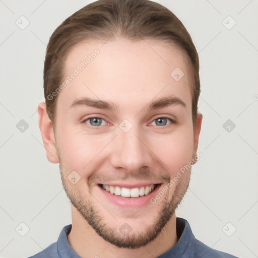 Joyful white young-adult male with short  brown hair and grey eyes