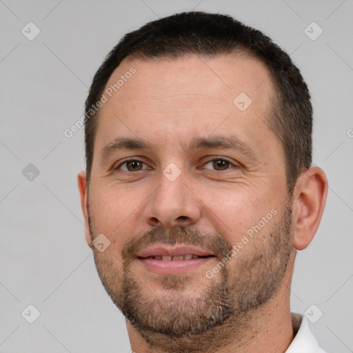 Joyful white adult male with short  brown hair and brown eyes