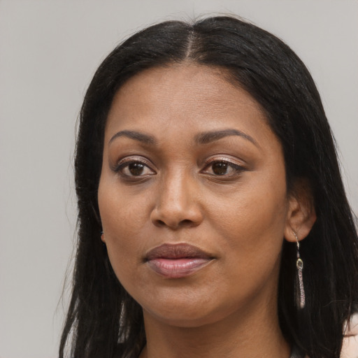 Joyful black adult female with long  brown hair and brown eyes