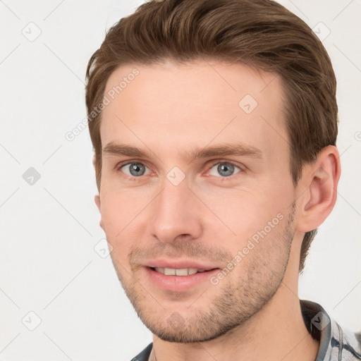 Joyful white young-adult male with short  brown hair and grey eyes