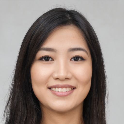 Joyful asian young-adult female with long  black hair and brown eyes