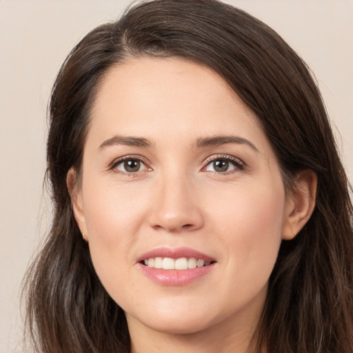 Joyful white young-adult female with long  brown hair and brown eyes