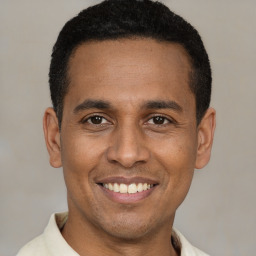 Joyful latino young-adult male with short  brown hair and brown eyes