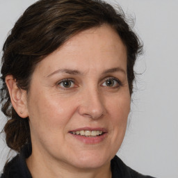 Joyful white adult female with medium  brown hair and grey eyes