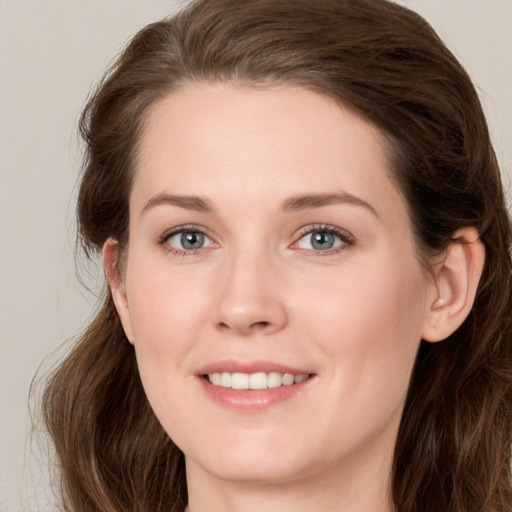 Joyful white young-adult female with long  brown hair and green eyes