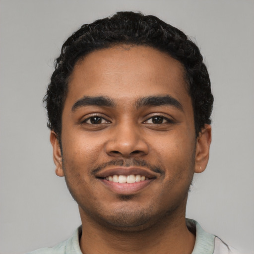 Joyful black young-adult male with short  black hair and brown eyes