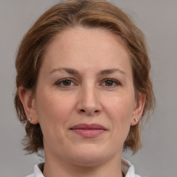 Joyful white adult female with medium  brown hair and grey eyes