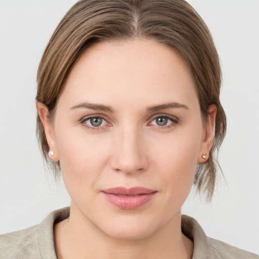 Joyful white young-adult female with medium  brown hair and grey eyes