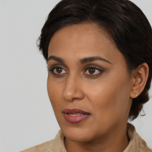 Joyful black young-adult female with medium  brown hair and brown eyes