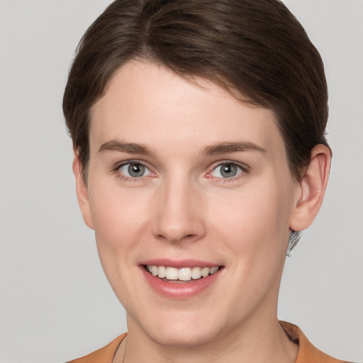 Joyful white young-adult female with short  brown hair and grey eyes