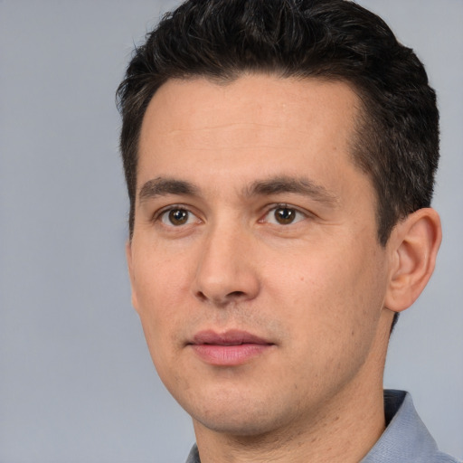 Joyful white young-adult male with short  black hair and brown eyes