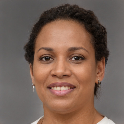 Joyful black young-adult female with short  brown hair and brown eyes