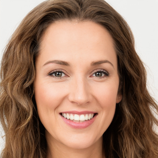 Joyful white young-adult female with long  brown hair and green eyes