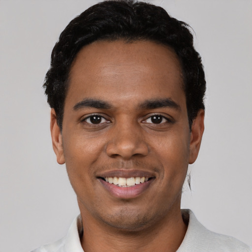 Joyful black young-adult male with short  black hair and brown eyes