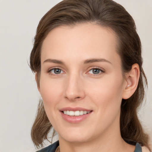 Joyful white young-adult female with medium  brown hair and grey eyes