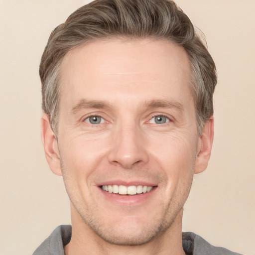 Joyful white adult male with short  brown hair and grey eyes