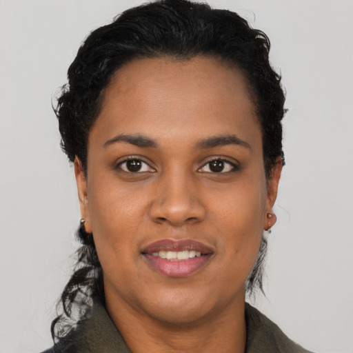 Joyful black young-adult female with short  black hair and brown eyes