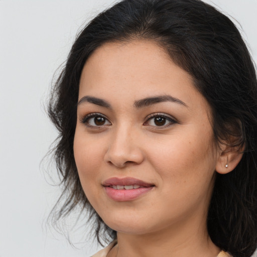 Joyful latino young-adult female with long  brown hair and brown eyes