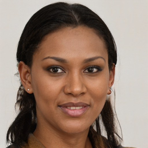 Joyful black young-adult female with long  brown hair and brown eyes