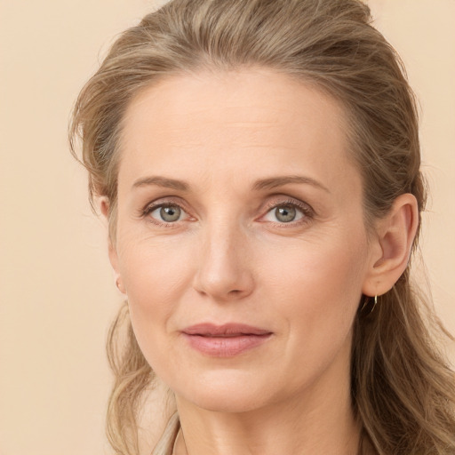 Joyful white adult female with long  brown hair and grey eyes