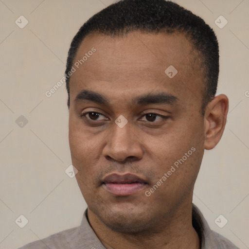 Joyful black young-adult male with short  black hair and brown eyes