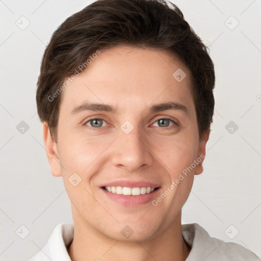 Joyful white young-adult male with short  brown hair and grey eyes