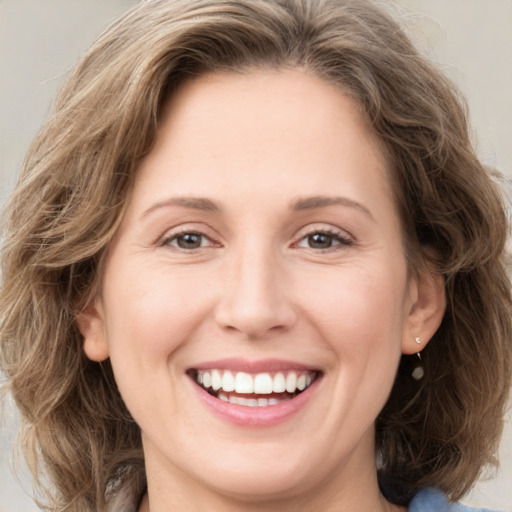 Joyful white young-adult female with medium  brown hair and green eyes