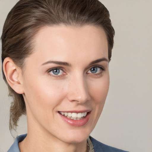 Joyful white young-adult female with medium  brown hair and grey eyes