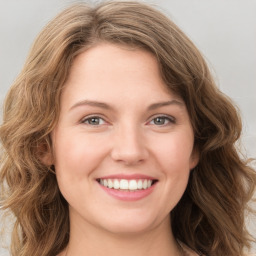 Joyful white young-adult female with long  brown hair and green eyes