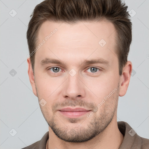 Joyful white young-adult male with short  brown hair and grey eyes