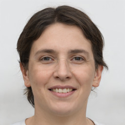 Joyful white young-adult female with medium  brown hair and grey eyes