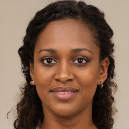 Joyful black young-adult female with long  brown hair and brown eyes