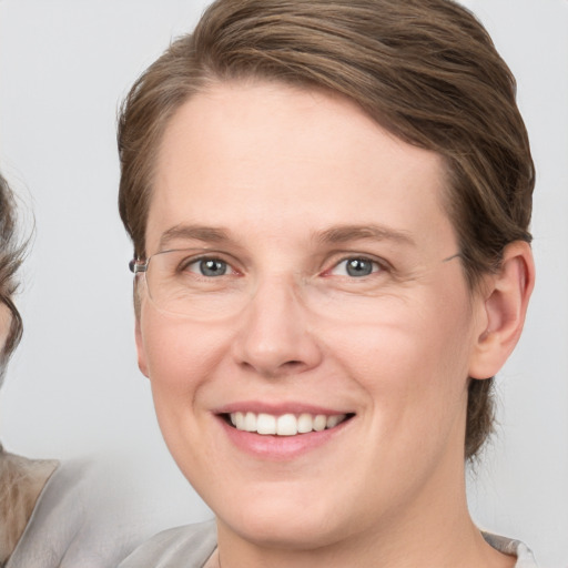 Joyful white young-adult female with medium  brown hair and grey eyes