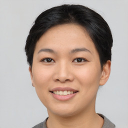 Joyful asian young-adult female with short  black hair and brown eyes