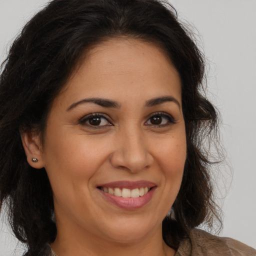 Joyful latino adult female with long  brown hair and brown eyes