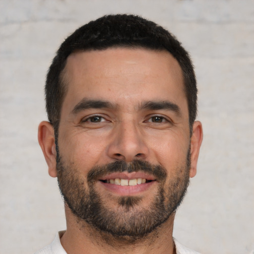 Joyful white young-adult male with short  black hair and brown eyes