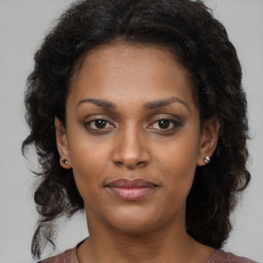 Joyful black young-adult female with medium  brown hair and brown eyes