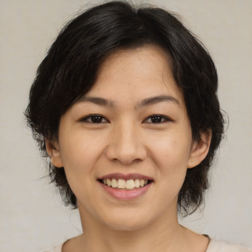 Joyful asian young-adult female with medium  brown hair and brown eyes