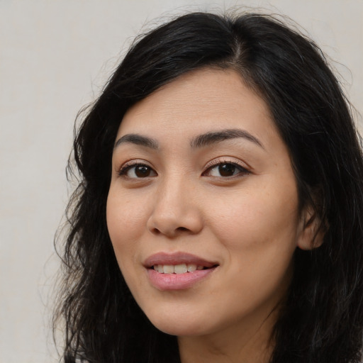 Joyful latino young-adult female with long  black hair and brown eyes