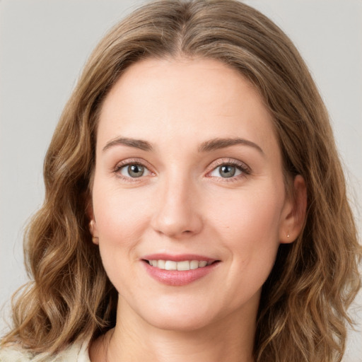 Joyful white young-adult female with long  brown hair and green eyes