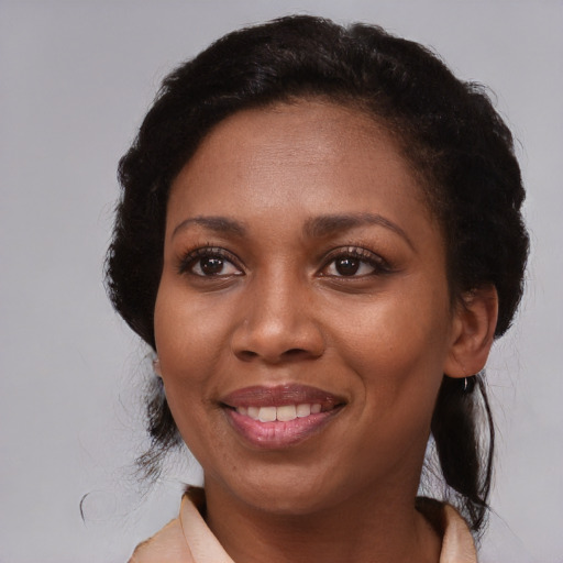 Joyful black adult female with medium  brown hair and brown eyes