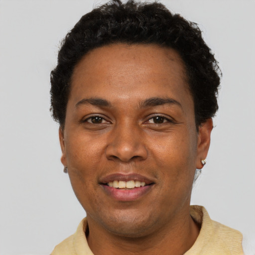 Joyful black adult female with short  black hair and brown eyes
