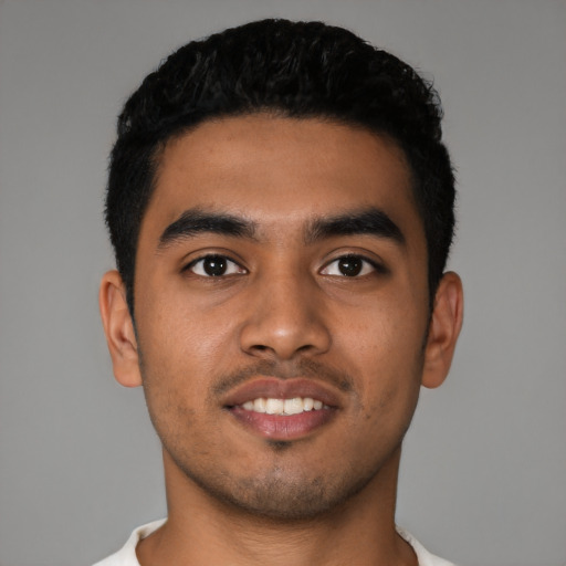 Joyful latino young-adult male with short  black hair and brown eyes