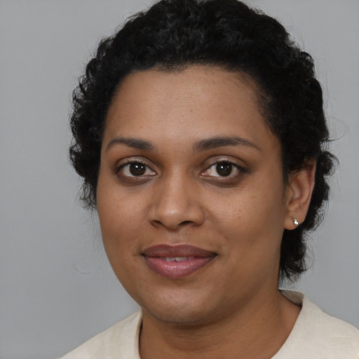 Joyful black young-adult female with short  black hair and brown eyes