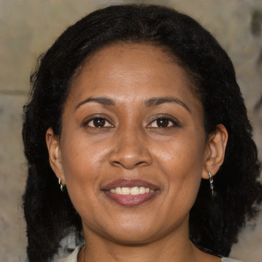Joyful latino adult female with medium  brown hair and brown eyes
