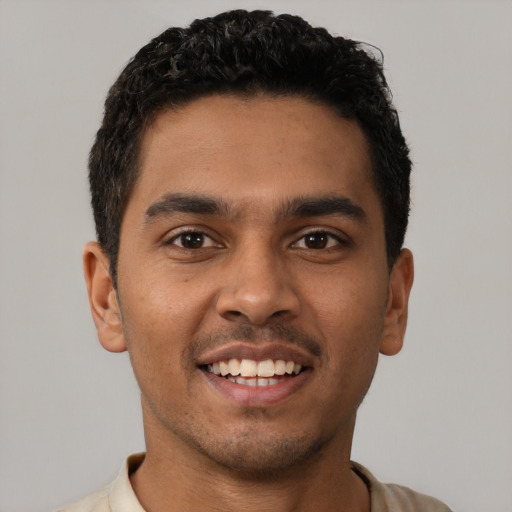 Joyful latino young-adult male with short  brown hair and brown eyes